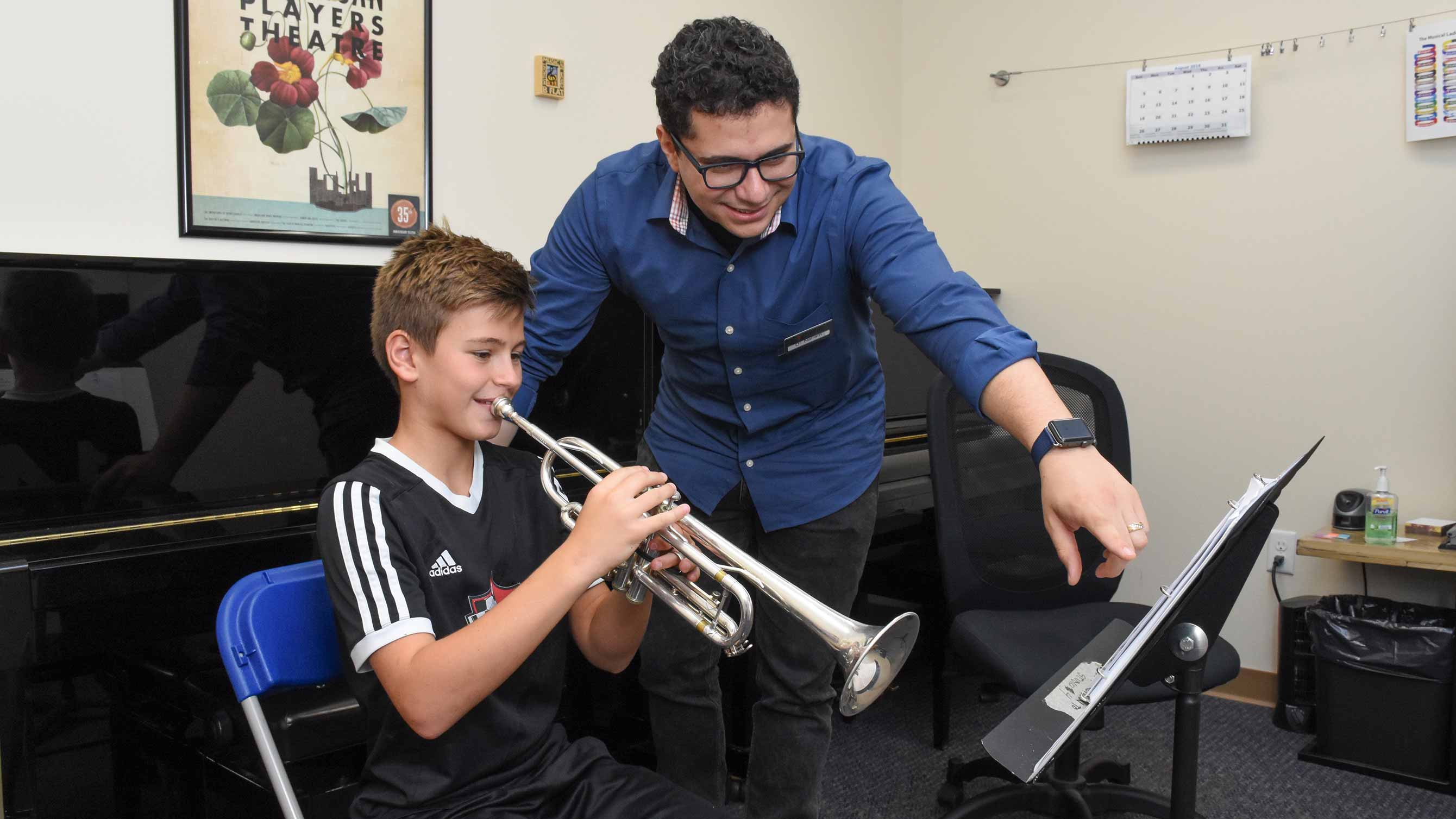 Photo of boy taking trumpet lesson